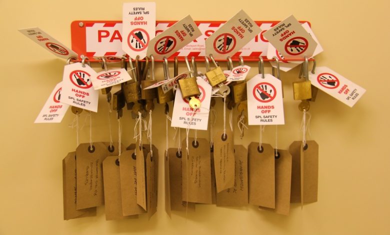 Open Padlocks hanging on wall with signs: "hands off"